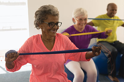 Happy Diverse Senior Woman Exercising with Resistance